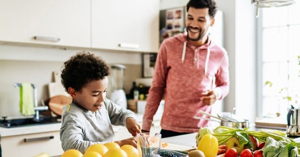 Dad and son prepping food together in kitchen