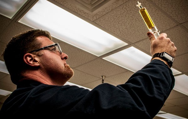 Transformer Oil Analyses Technician Holding Sample