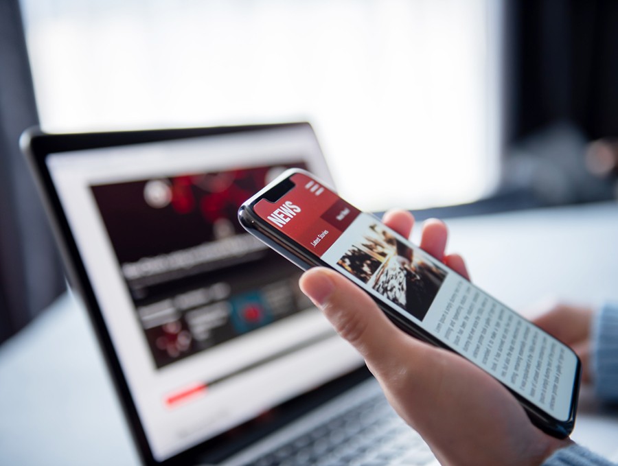 Online news on a smartphone and laptop. 