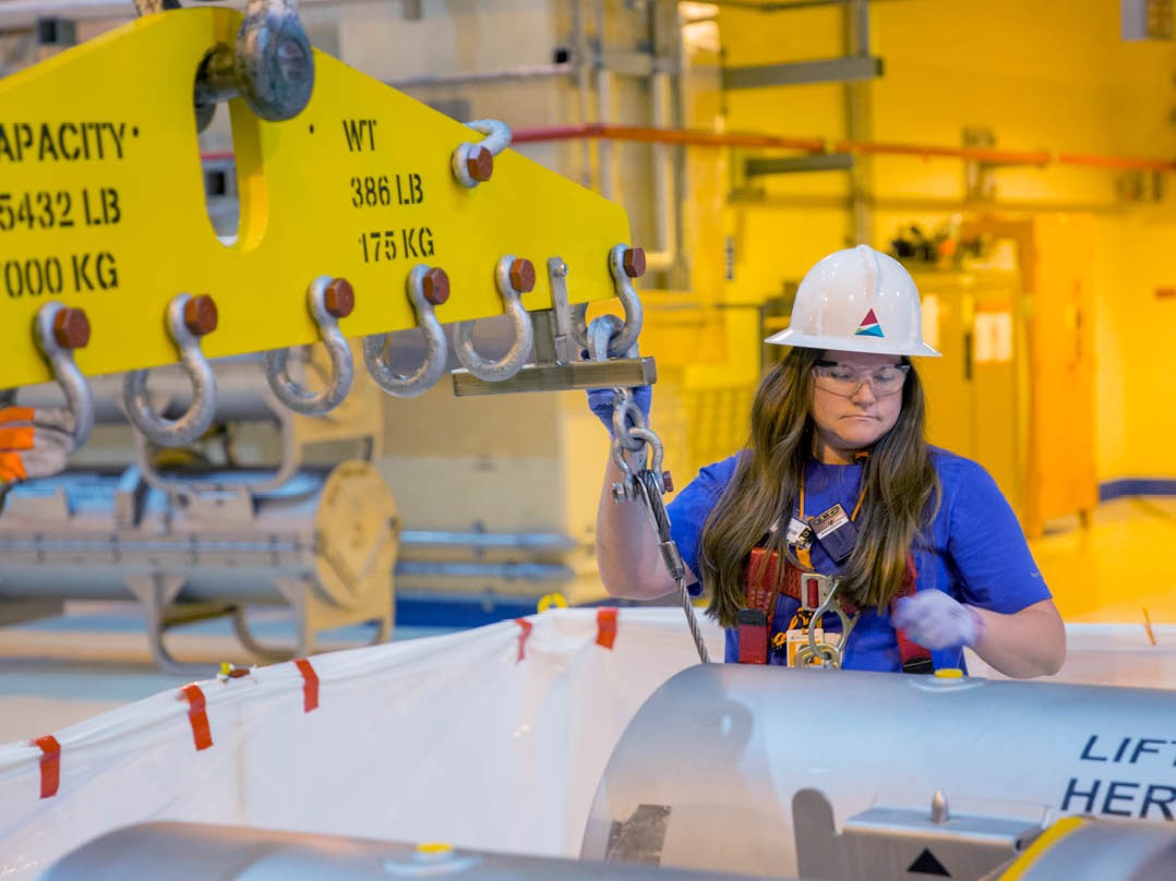 Women in hard hat working in plant