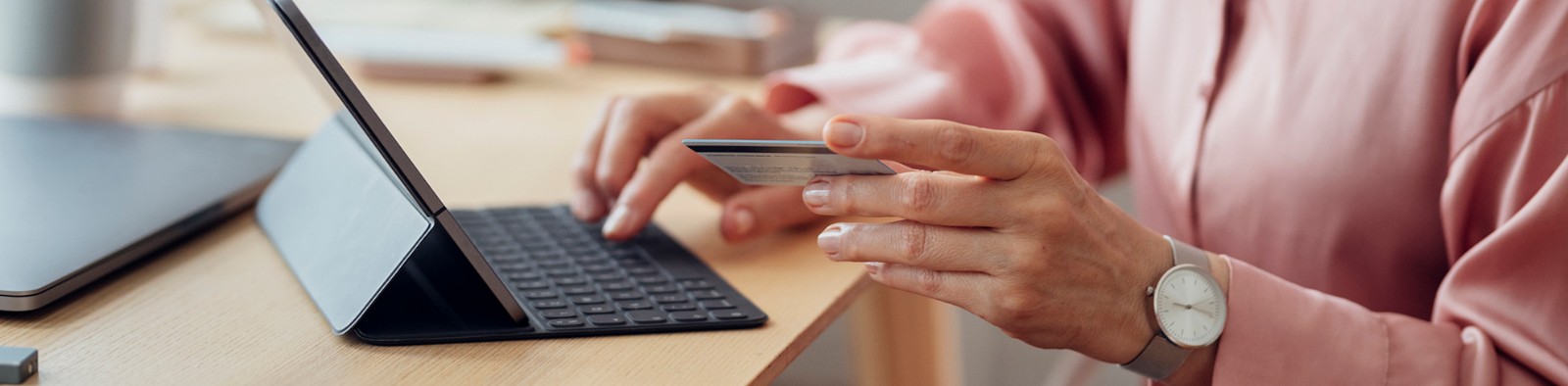 Person entering their credit card online via a tablet