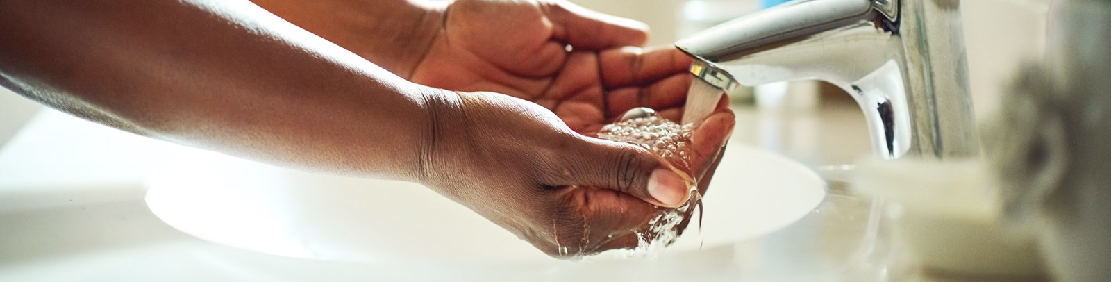 Hands washing in a sink 