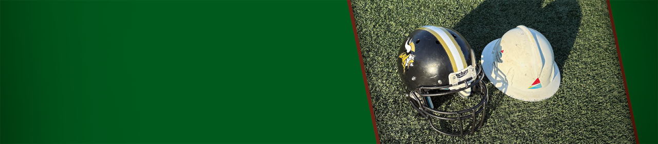 A football helmet and an Alabama Power hardhat sit on the turf of a football field.