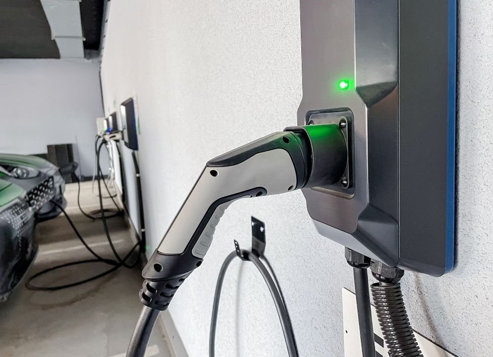 EV chargers on a wall being used to charge vehicles.