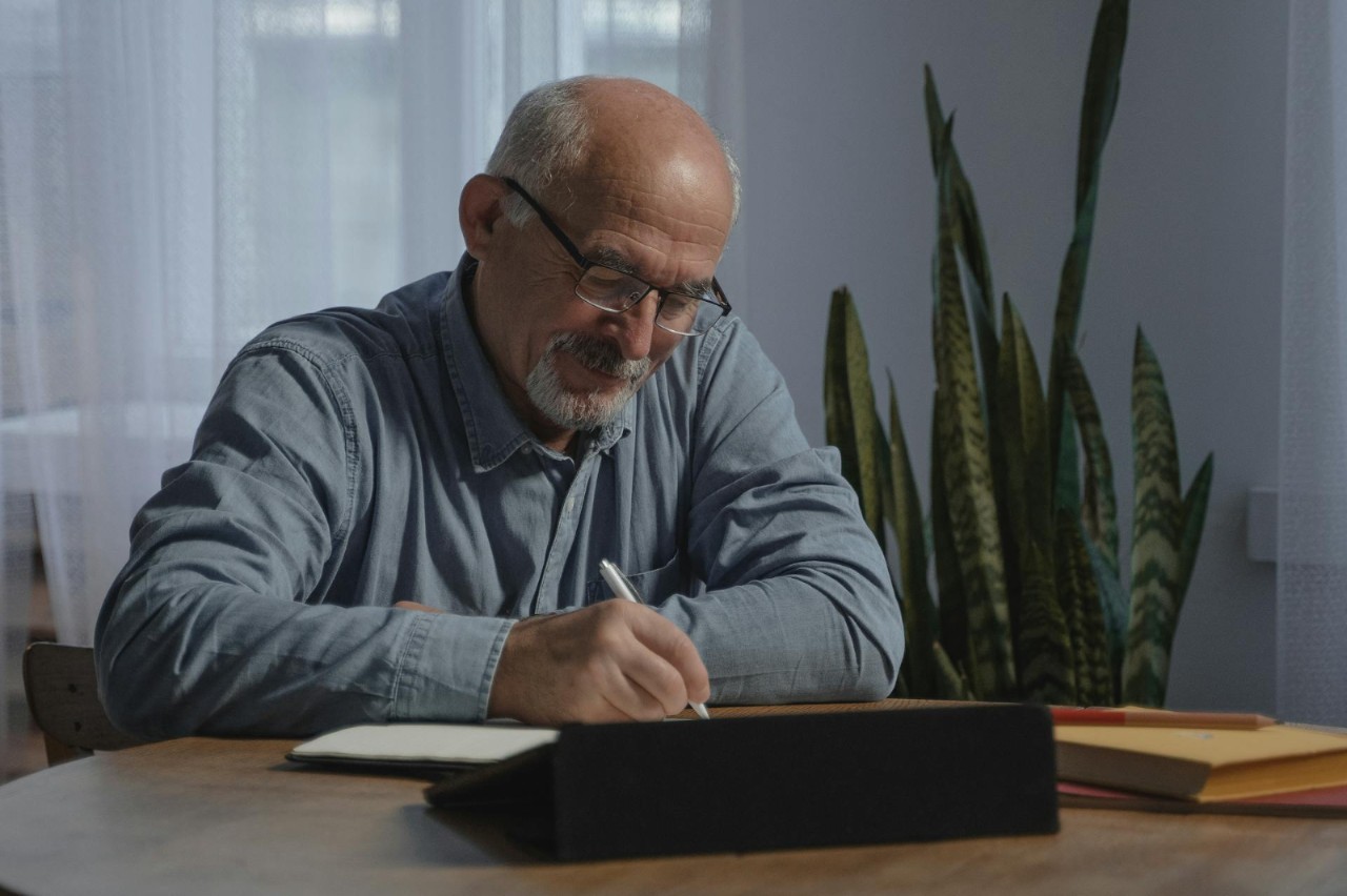 elderly man using a pen