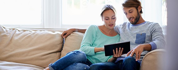 Couple reviewing tablet on couch 