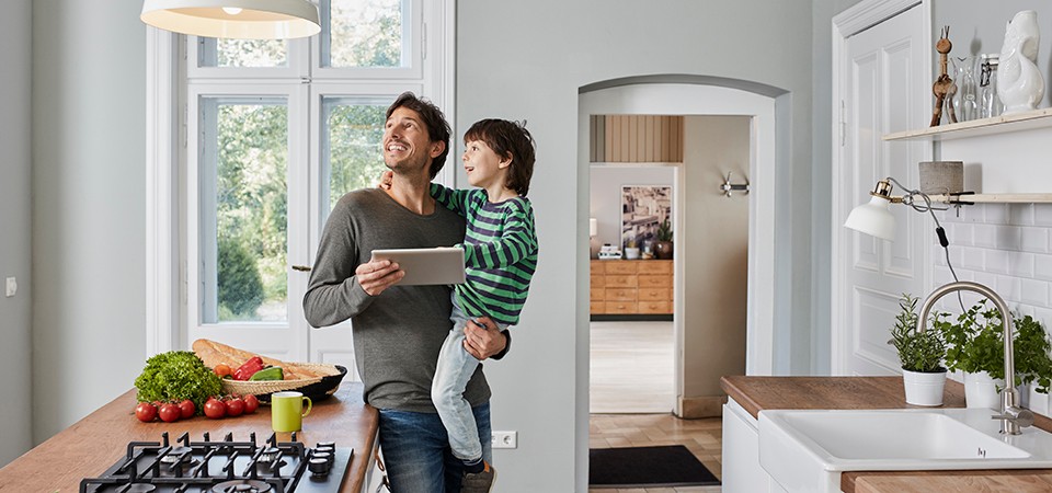 Father and son in kitchen with tablet 