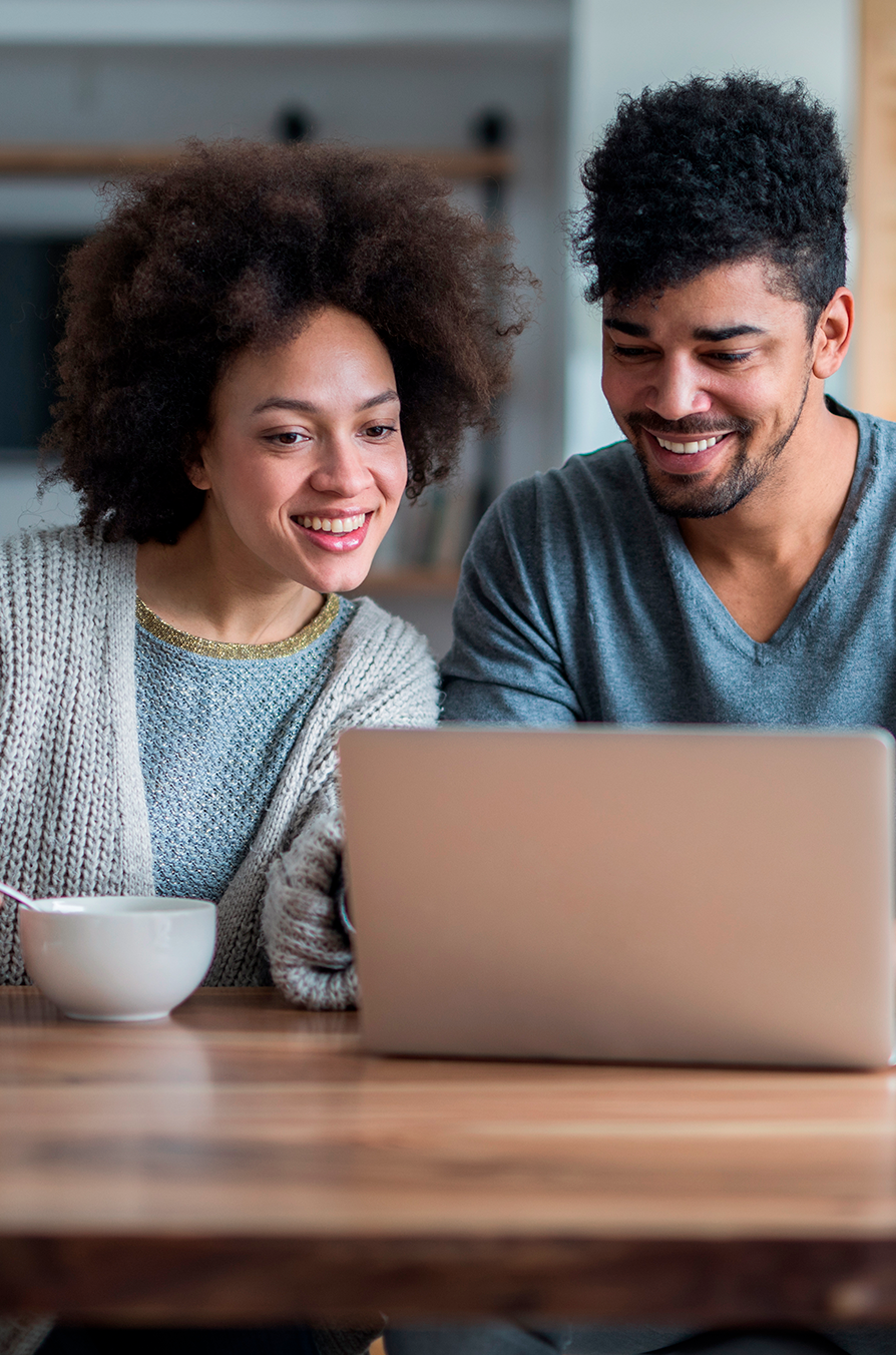  Happy black couple using laptop together at home
